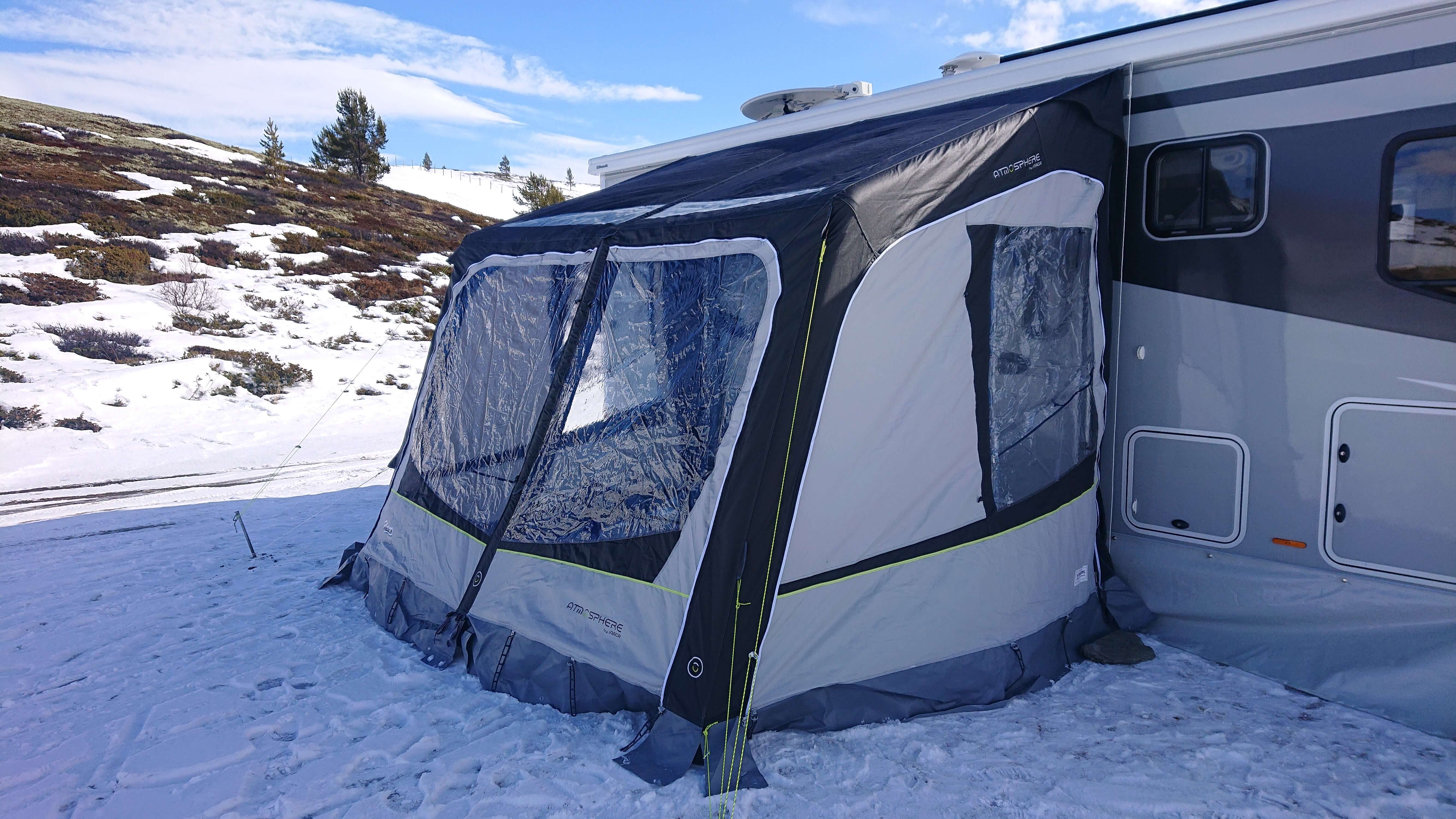 I bildet er det et lukket fortelt festet til en bobil som står på høyfjellet i snø. 